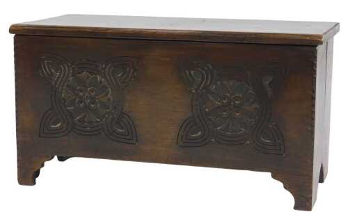 A 20thC oak coffer, with a hinged lid, the front frieze carved with flowers within a Celtic knot,...