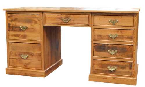 A pine twin pedestal desk, with one central drawer flanked by four drawers to the left and two...