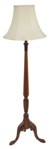 An early 20thC mahogany standard lamp, with an octagonal and fluted column, raised on three...
