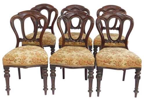 A set of six Victorian mahogany balloon back dining chairs, the serpentine seats upholstered in...