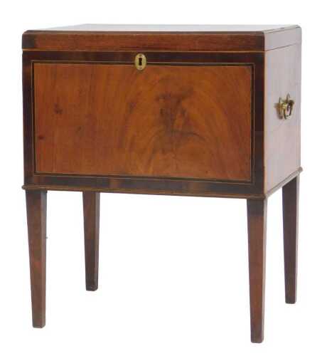 A George III mahogany cellarette, with twin brass carrying handles, the hinged lid opening to...
