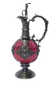A Victorian Renaissance Revival ewer, with ornate silver-plated mounts over a cranberry glass...