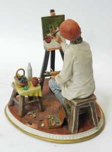 A Capodimonte porcelain figure, modelled as an artist seated at an easel, painting a still life,... - 2