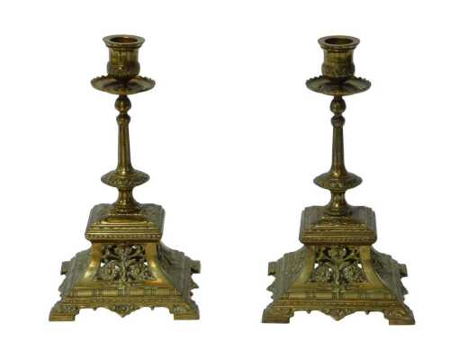 A pair of Victorian brass candlesticks, each with a circular drip tray, the square outswept base...