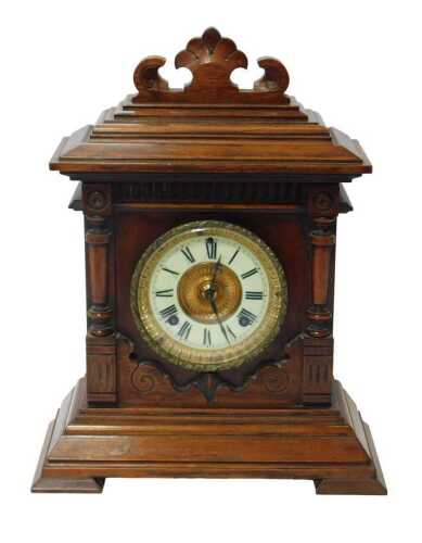 An Ansonia Clock Company oak cased mantel clock, the brass circular dial with a cream enamel...