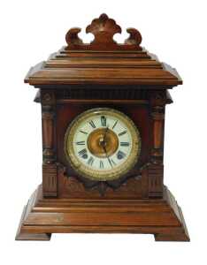 An Ansonia Clock Company oak cased mantel clock, the brass circular dial with a cream enamel...
