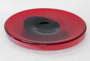 A late 20thC red glass dish, with central black abstract decoration, 34cm diameter. - 2