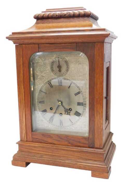 A Gustav Becker oak cased mantel clock, the silvered face bearing a circular Roman numeric dial,...