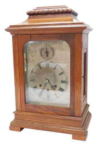 A Gustav Becker oak cased mantel clock, the silvered face bearing a circular Roman numeric dial,...