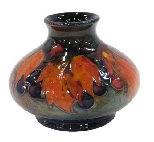 A Moorcroft pottery flambe Leaf and Berry pattern squat vase, of bellied circular form on...