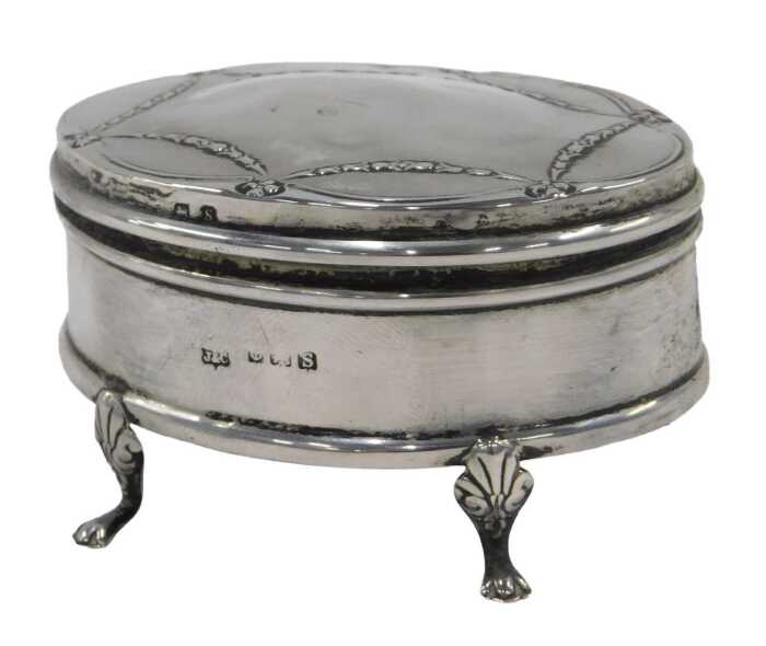 A George V silver jewellery casket, of oval form, with an outer raised bell flower garland...