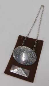 A 20thC sterling silver gin label, of oval form, etched with flowers, with chain on apex... - 2