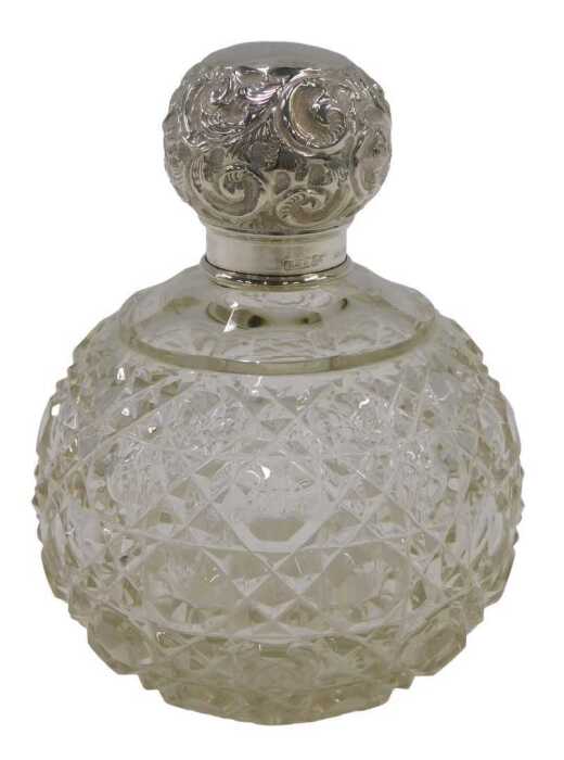 An Edward VII cut glass silver topped perfume bottle, of bulbous form, with a repeat hobnail cut...