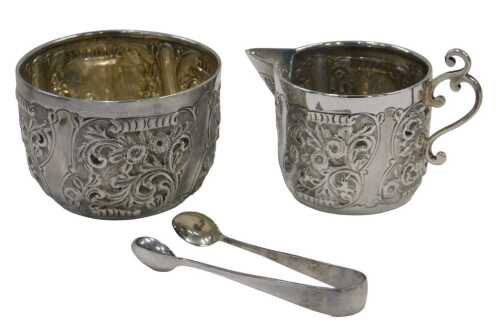 A Victorian two piece sugar bowl and milk jug set, each piece heavily repousse decorated with...