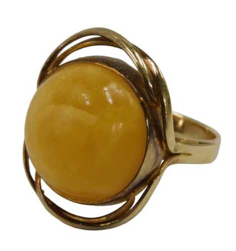 An amber dress ring, the butterscotch amber, in a rub over setting with outer crossover twist...