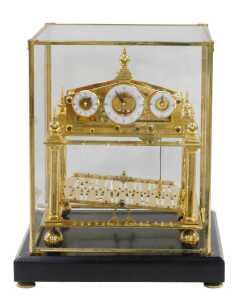 A 20thC Congreve rolling ball clock, in a highly elaborate gilt brass case, surmounted by an orb...