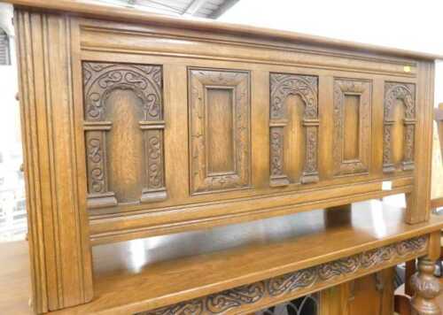 An Old Charm style heavily carved oak three panelled coffer, on shaped stiles.