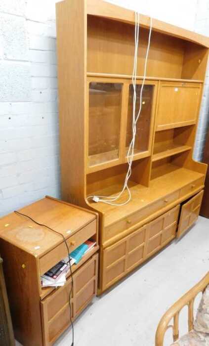 A Nathan teak display cabinet, the upper section with glazed doors and open shelves, above three...