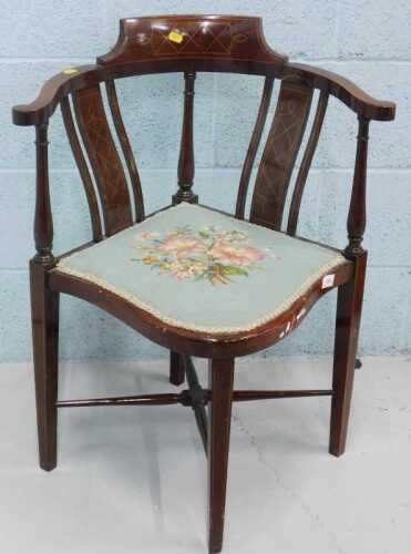 An Edwardian mahogany and boxwood strung corner chair, with overstuffed seat in floral material,...