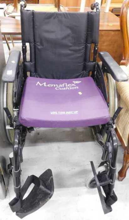 An Action wheelchair, in black, with Memaflex cushion.