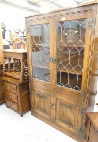Various Old Charm style furniture, etc., a linen fold display cabinet with lead glazed panelled...