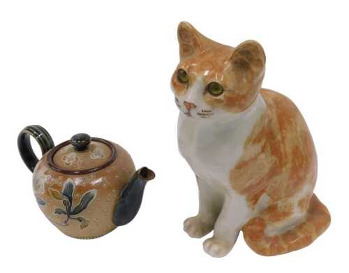 A 20thC Winstanley pottery figure of a standing cat, with glass eyes, in brown and white, marked...