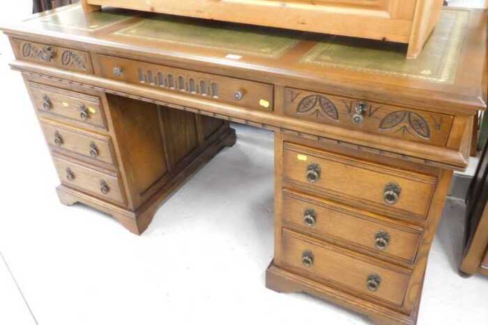 An Old Charm style twin pedestal writing desk, with three part tooled green leather top, raised...