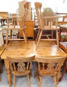 A 20thC pine dining table, with oblong top, on heavy turned legs, and four chairs, each with...