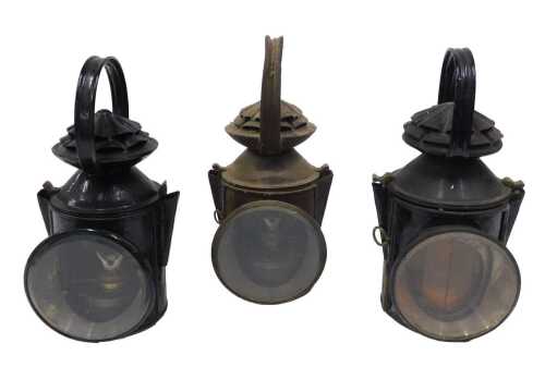 Three early 20thC metal railway lamps, to include one labelled Heckington III, in black with...