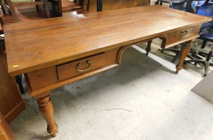 A large rectangular hardwood desk, with two frieze drawers on turned legs, purchased in...