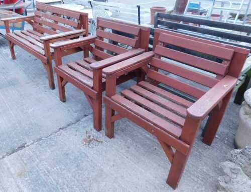 A garden set, comprising slatted wooden two seater bench and two similar armchairs, each partially painted brown.