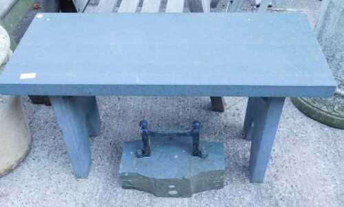 An outside stone side table, and a boot scraper with H shaped iron centre section.