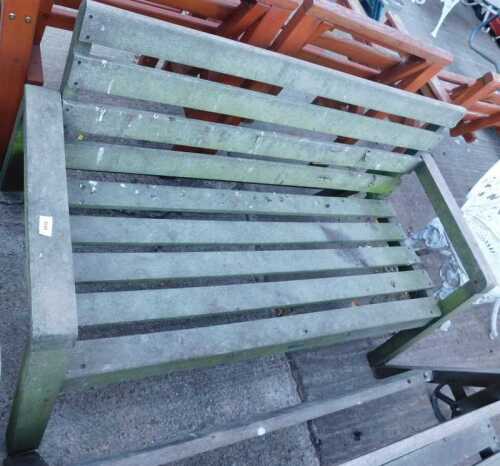 A slatted garden bench, painted green.