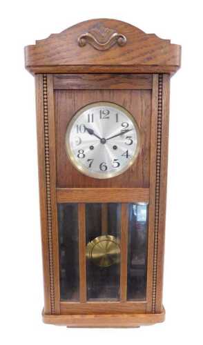An early 20thC oak cased wall clock, the 16cm silvered Arabic dial in a three part glazed case,...