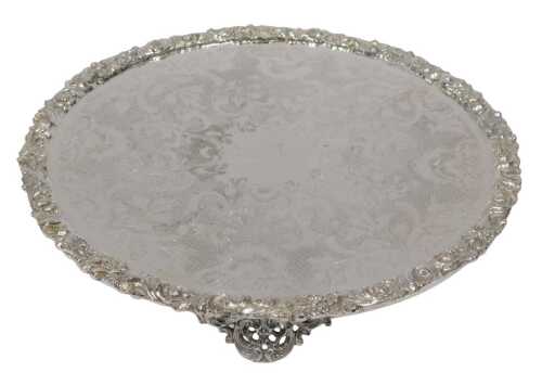 A late 19thC silver plated waiter, the centre chased with scrolls and flowers, the border raised...