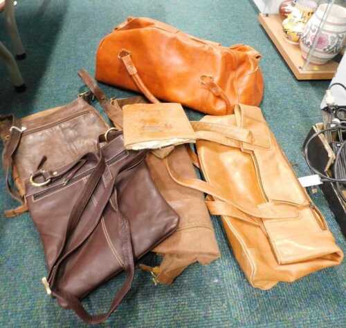 A leather overnight bag, containing various other handbags.