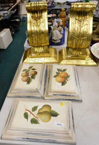 Two giltwood acanthus scroll wall sconces, and three fruit painted raised scroll wall plaques.