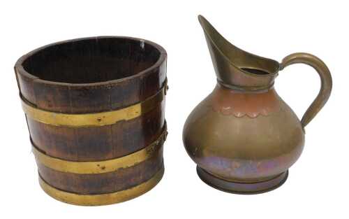 An early 20thC oak coopered jardiniere, with brass banding, 27cm high, a copper and brass jug,...