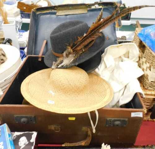 A travel case containing a quantity of hats, Battersby and Co silk top hat, various other hats,...