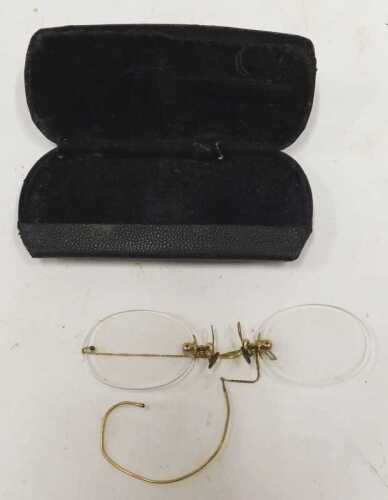 An early 20thC gold coloured pince nez, partially cased.