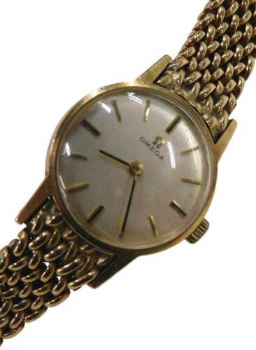 A 9ct gold Omega ladies wristwatch, with a silvered and baton watch face, on a full bar bracelet,...