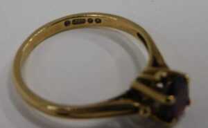 A 9ct gold garnet dress ring, the oval cut garnet in a four claw raised basket setting, ring... - 2