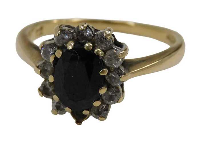 A 9ct gold floral cluster ring, set with central oval cut garnet, surrounded by imitation...