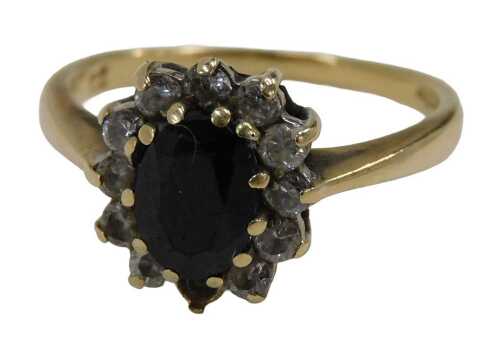 A 9ct gold floral cluster ring, set with central oval cut garnet, surrounded by imitation...