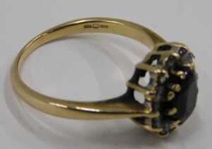 A 9ct gold floral cluster ring, set with central oval cut garnet, surrounded by imitation... - 2