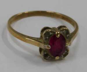 A 9ct gold dress ring, centred with an oval cut garnet and flanked by four CZs, in a petalated... - 2