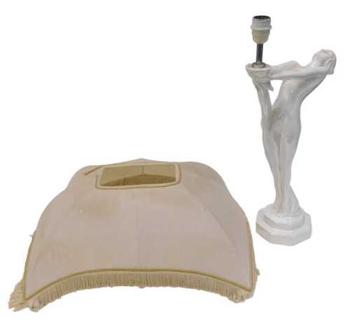 A 20thC plain glazed Art Deco table lamp, formed as a lady holding the cream material shade,...