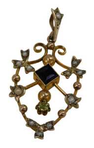 An Edwardian pendant, of shield shape, set with amethyst, peridot and seed pearls, yellow metal...