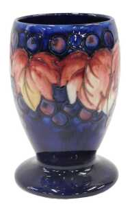 A Moorcroft pottery Leaf and Berry pattern goblet vase, on blue ground, 15cm high.