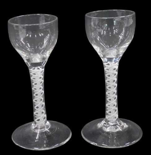 An English cordial glass, with shallow circular plain bowl, on double air twist stem and conical...